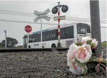  ?? WARWICK SMITH/STUFF ?? A roadside tribute to June Eynon, the bus driver who died at a railway crossing near Palmerston North after a collision with a train on Wednesday.