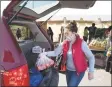  ?? Associated Press ?? A food pantry volunteer loads a vehicle in East Hartford.