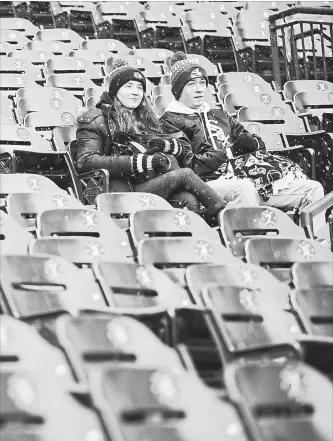  ?? ASSOCIATED PRESS FILE PHOTO ?? Two fans sit in the stands before a game between the White Sox and Tampa Bay Rays in Chicago on Monday. There were only 972 other people with them in the stadium.