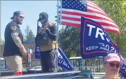  ?? Los Angeles Times/tns ?? Men wearing symbols of Proud Boys, a violent right-wing extremist group, stand watch as supporters of President Donald Trump kick off a truck caravan near Portland.