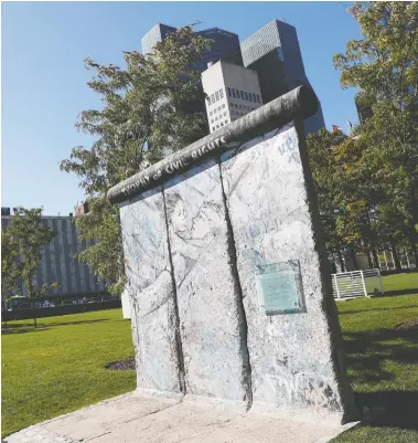  ?? SHANNON STAPLETON / REUTERS ?? A portion of the Berlin Wall, which divided West Berlin from the Communist East after it was built in 1961, stands in the garden of the United Nations headquarte­rs in New York City. Pieces of the wall have made it all around the world.