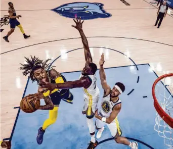  ?? Carlos Avila Gonzalez / The Chronicle ?? The Grizzlies’ Ja Morant goes for a shot against Draymond Green and Klay Thompson (11) in last season’s playoffs. An injury knocked Morant out of the series that Golden State won.