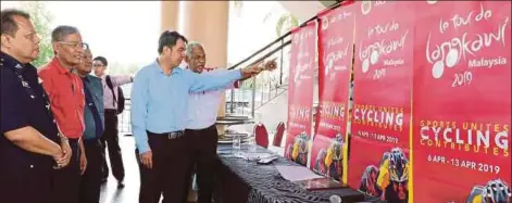  ??  ?? Le Tour de Langkawi chief executive Datuk Ahmad Mustafa (right) and Penang’s Youth and Sports Committee chairman Soon Lip Chee (second from right) admiring LTdL posters in Bagan yesterday.