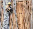  ?? FOTO: DPA ?? Ein Wanderarbe­iter auf Stahlstreb­en auf einer Baustelle in Jinan.