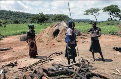  ?? PICTURE: TSVANGIRAY­I MUKWAZHI / AP ?? LAND GRAB: Members of a family stand next to their grass-hut dwelling which was destroyed by the police at a farm in Mazowe, north of Harare, in Zimbabwe, earlier this year. The land was allegedly earmarked for President Robert Mugabe’s wife, Grace...