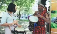  ?? REN PENGFEI / XINHUA ?? A Kenyan student from Beijing Language and Culture University teaches a Chinese student how to play a Kenyan drum in Beijing in June.