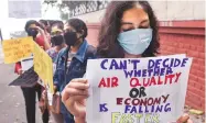  ?? PHOTOS: PTI ?? ( Left) Devotees brave polluted air and Yamuna to worship the Sun god in New Delhi on Sunday, even as youngsters hold a protest march demanding better air in the Capital