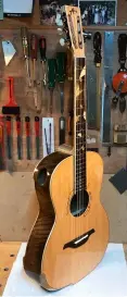  ?? ?? Alex’s latest build is an English walnut fingerstyl­e acoustic that incorporat­es arm and body bevels for ergonomic benefits and a fixed pinless bridge