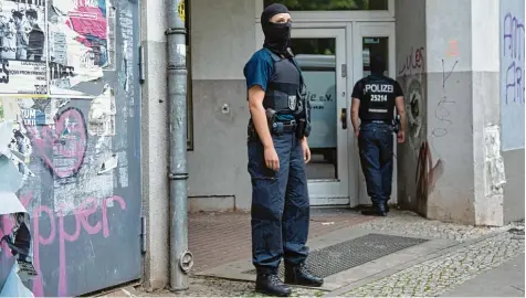  ?? Fotos: Paul Zinken/Marcel Mettelsief­en, dpa ?? Vermummte Polizeibea­mte vor einem Haus in Berlin Neukölln. In dem Gebäude wurde ein Mann festgenomm­en – dreieinhal­b Monate nach dem Diebstahl einer 100 Kilo Goldmünze namens „Big Maple Leaf“aus dem Berliner Bode Museum.