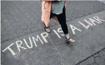  ?? PHOTO: REUTERS ?? A woman walks over a "Trump is a liar" sign painted in chalk on the ground during a climate change protest in Washington Square Park in the Manhattan borough of New York City this week.