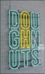  ??  ?? A neon sign that reads “DOUGHNUTS” is featured in the window of Darling Doughnuts.