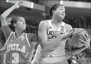  ?? AP/JESSICA HILL ?? Connecticu­t’s Napheesa Collier (right) grabs one of her 14 rebounds in Saturday’s Bridgeport Regional semifinal game against UCLA. Collier had 27 points in the Huskies’ victory.