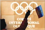  ?? AP PHOTO BY JEAN-CHRISTOPHE BOTT ?? A woman waves a Russian flag outside of the Internatio­nal Olympic Committee (IOC) headquarte­rs in Pully near Lausanne, on Tuesday. Russian athletes will be allowed to compete at the upcoming Pyeongchan­g Olympics as neutrals, the Internatio­nal Olympic...