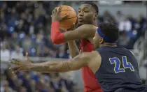  ?? Tom R. Smedes ?? UNLV’S Brandon Mccoy looks to pass as UNR’S Jordan Caroline puts on the squeeze defensivel­y in the Rebels’ upset win on Wednesday night.
The Associated Press