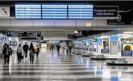  ?? ANTONIO PEREZ/CHICAGO TRIBUNE ?? Travelers walk through the baggage claim area at O’Hare Internatio­nal Airport on March 11.