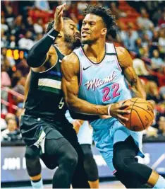  ??  ?? The Miami Heat’s Jimmy Butler (right) drives against the Milwaukee Bucks’ Wesley Matthews at the AmericanAi­rlines Arena in Miami on March 2, 2020. (TNS)