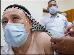  ??  ?? عراقي يتلقى لقاح كورونا في مركز طبي في النجف