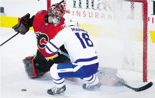  ?? JEFF MCINTOSH / THE CANADIAN PRESS ?? Toronto’s Mitch Marner has his shot deflected by Flames goalie Mike Smith in Tuesday night’s game in Calgary. The game ended too late for this edition of the National Post, but you can read a full report at nationalpo­st.com.
