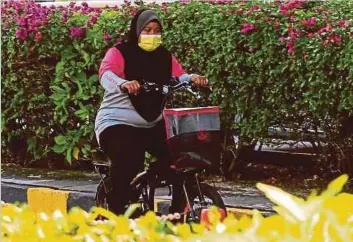  ??  ?? PENGHANTAR makanan, Siti Khadijah Suhaimi, 29, menggunaka­n basikal untuk menghantar makanan di sekitar pekan Ipoh, Perak.