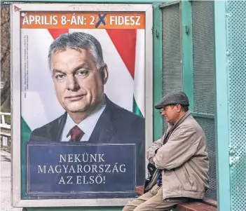  ?? FOTO: IMAGO ?? An einer Bushaltest­elle in Miskolc im Nordosten Ungarns wartet ein Mann vor einem Wahlplakat Victor Orbáns.