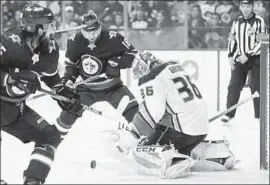  ?? John Woods Associated Press ?? THE PUCK is free, with Ducks goaltender John Gibson trying to track it down and the Jets’ Mathieu Perreault, left, and Bryan Little trying to get it in the net.