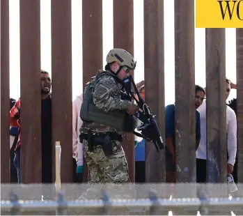  ?? GREG BULL / THE ASSOCIATED PRESS ?? A U.S. Customs and Border Protection officer walks along a barrier at the Mexico-U.S. border, in San Diego, Calif., on Sunday. Migrants attempted to penetrate several points along the border.