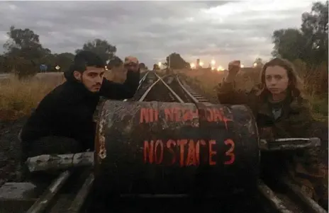  ??  ?? PROTEST: Jonathan Manoel Pinheiro (left) and Emma Jade Dorge from Front Line Action on Coal Brisbane chained themselves to a concrete barrel on the rail line at Jondaryan in June.