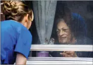  ?? JUSTIN WAN, JOURNAL STAR ?? Jen Mathews (left) talks through a window to resident Patty Nieveen at Lexington Assisted Living Center.