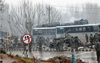  ?? Umer Asif / Associated Press ?? Indian paramilita­ry soldiers probe the wreckage of a bus after an explosion in Pampore, Indiancont­rolled Kashmir, in what is considered the deadliest attack on security forces in the region.