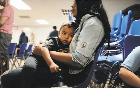  ?? Spencer Platt / Getty Images ?? A woman and her son rest Thursday at a Catholic Charities center in McAllen, Texas, after recently crossing the border.