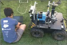  ?? Photo contribute­d ?? Shokoofeh Pourmehr, a PhD student from Simon Fraser University, prepares her Husky robot at field trials in Kelowna this week.