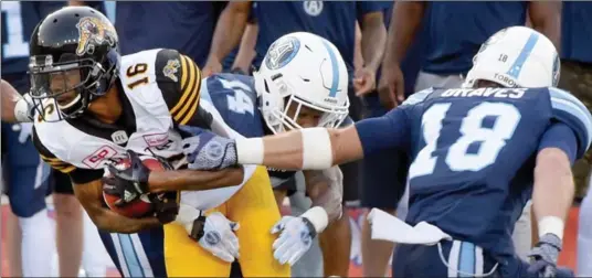  ?? CATHIE COWARD, THE HAMILTON SPECTATOR ?? Brandon Banks is tackled during first-quarter action against the Toronto Argos at Tim Hortons Field on Friday night. For more photos, visit the photograph­ers’ blog at thespec.com.