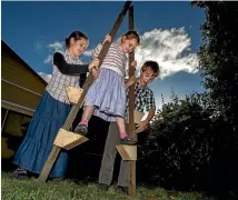  ??  ?? Christina Rimmer, 8, gets a hand using some home made stilts from Annaliese Wayman, 12, and Boone Wayman, 10.