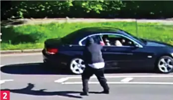  ??  ?? Brazen: The masked and hooded man runs down a grass verge towards the car. He opens fire at the woman driver, shattering a window, then shoots twice more