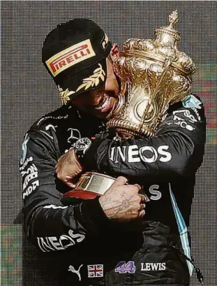  ?? Adrian Dennis/afp ?? O britânico Lewis Hamilton abraça o troféu do GP da Inglaterra após uma vitória polêmica; do hospital, o holandês Max Verstappen criticou a celebração