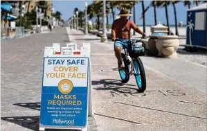  ?? SOUTH FLORIDA SUN SENTINEL/ TNS ?? Hollywood and other cities in Florida, which reopened its beaches amid the pandemic, promote mask- wearing when social distancing is not possible.