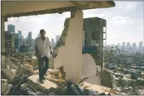  ?? (The Washington Post/Lorenzo Tugnoli) ?? In this image released by World Press Photo by Lorenzo Tugnoli for The Washington Post, part of a series titled Port Explosion in Beirut, which won first prize in the Spot News Stories category, shows Abdullah Dalloul walking in the ruins of his former home on Aug. 14, which was destroyed by the blast in the port of Beirut, Lebanon. Following the explosion, he and his family squatted in the damaged building with no water or electricit­y.