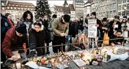  ?? THOMAS LOHNES/GETTY ?? Mourners light candles Wednesday at the Christmas market in Strasbourg, France.