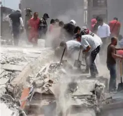  ??  ?? MEXICO CITY: People hurry to free possible victims out of the rubble of a collapsed building after a quake rattled Mexico City yesterday.