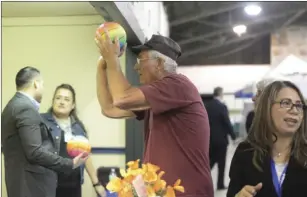  ??  ?? A resident in attendance takes a shot at a hoop in the Rabobank booth in order to claim a prize at the 20th annual Joint Chambers of Commerce Business Showcase. EDWIN DELGADO PHOTO