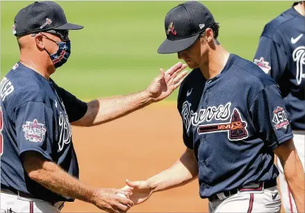  ?? CURTIS COMPTON/CURTIS.COMPTON@AJC.COM ?? Manager Brian Snitker pulls Kyle Wright in the second inning trailing 2-1 against Tampa Bay in Sunday’s opening game of spring training. “I liked the stuff,” Snitker said. “He threw some good breaking balls at times, popped his fastball. It was OK. He lost a couple early in that first inning but he came back and threw the ball well. Overall, I thought the stuff was good.”