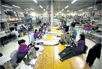  ?? THE ASSOCIATED PRESS FILES ?? Workers manufactur­e car dash mats at a factory in Ciudad Juarez, Mexico. In Mexico where the auto industry has boomed under NAFTA, the industry has created a class of workers who are taking home as little as $50 per week.