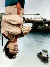  ??  ?? THE GREAT ESCAPE Escapologi­st Timothy DillRussel­l, the stunt advisor to the West End musical Man Of Magic – about Harry Houdini – hangs upside down over the Thames in 1966