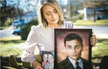  ?? DAN GLEITER/PENNLIVE.COM ?? Allison Klunk, of East Manchester Township, holds photos of her son Justin while standing in the backyard of her home where she last talked with him before he died of an opioid overdose on Oct. 23, 2015.