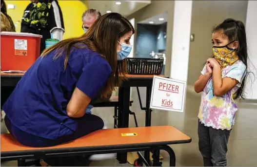  ?? PAUL RATJE/THE NEW YORK TIMES ?? Mila Pagador, 5, speaks to registered nurse Ashley Bean before getting her dose of the COVID-19 vaccine in Albuquerqu­e, N.M., last fall. The odds of Mila and her friends getting omicron were greater than with earlier variants of the coronaviru­s, but the effects are much less severe in almost all cases.