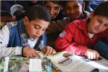  ??  ?? Iraqi children read books at school.