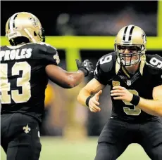  ?? Stac y R ev e r e /G e t ty I m ag e s/ f i l e s ?? Behind quarterbac­k Drew Brees, right, the New Orleans Saints have enjoyed a turnaround season.