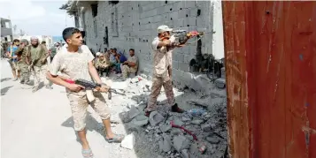  ?? — Reuters ?? A fighter of Libyan forces allied with the UN-backed government aims his weapon towards IS holdouts at the frontline of fighting in Cambo area in Sirte.