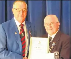  ??  ?? Kent secretary Mick Bannister receives his award from Bowls England junior vice-president Bill Smith