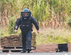  ??  ?? BOMB SQUAD: A member of the Explosive Ordnance Response Team deals with the device on Wednesday.